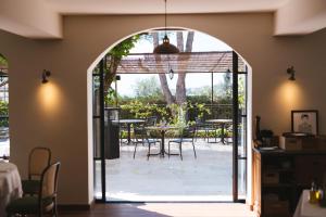 an open door to a patio with tables and chairs at Auberge du Redier in Colomars