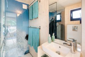 a bathroom with a sink and a glass shower at Hausboot AHOI hochwertiges Hausboote mit großer Terrasse und Kamin in Hamburg