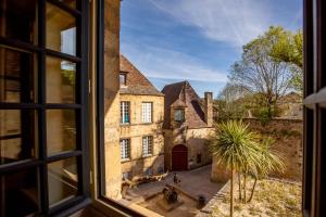 an open window looking out at an old building at Hôtel des Récollets in Sarlat-la-Canéda