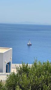 un barco en el océano con una vela en Sifnos "Sofia apartments" sea view, en Faros