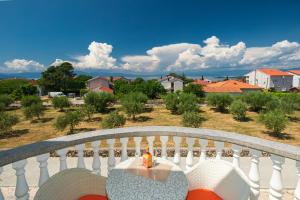 een balkon met een tafel en uitzicht op een stad bij Vila Panorama in Malinska