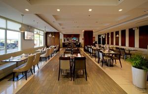 a dining room with tables and chairs in a restaurant at Action Hotel Ras Al Khaimah in Ras al Khaimah