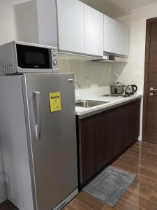 eine Küche mit einem Kühlschrank aus Edelstahl und einer Mikrowelle in der Unterkunft Air Residences 1-Bedroom condo in Makati in Manila