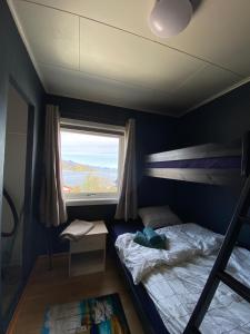 een slaapkamer met een stapelbed en een raam bij House in the heart of Lofoten with spectacular view in Reine
