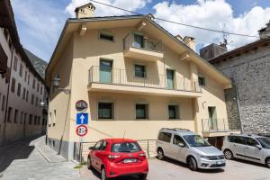 dos coches estacionados frente a un edificio en Café Quinson Relais de Charme en Morgex