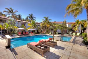 einen Pool in einem Resort mit Liegestühlen und Palmen in der Unterkunft Boca Olas Resort Villas in La Libertad