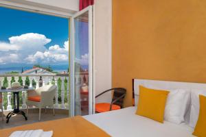 a bedroom with a bed and a balcony with a view at Vila Panorama in Malinska