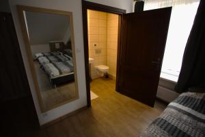 a bedroom with two beds and a mirror and a bathroom at Stara Szkoła in Sokółka