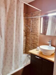 La salle de bains est pourvue d'un lavabo et d'un rideau de douche. dans l'établissement Mandelieu Grand studio avec Piscine et proche de la Mer, à Mandelieu-la-Napoule