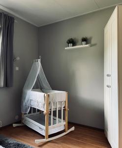 a baby crib in a room with a gray wall at Ferienhaus "Zauberwald" mit Pelletofen & Sauna in Meschede