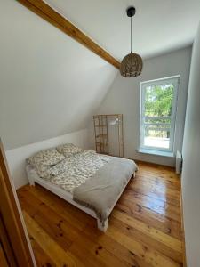 1 dormitorio con 1 cama en el suelo de madera en Kisielkowo en Wilkasy