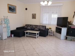 een woonkamer met een bank en een tv bij Villa Sunny Day Asprovalta in Asprovalta +24 foto's