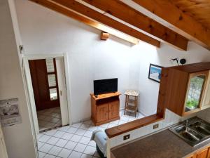 een keuken met een wastafel en een tv aan de muur bij Chalet Migazzi - mansarda in Cogolo