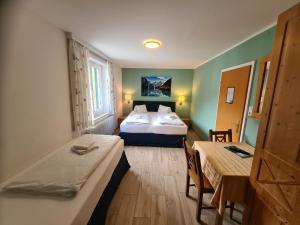 a hotel room with two beds and a table and chairs at B&B Hallstatt Lake OBERTRAUN self check in in Obertraun