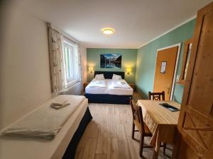 a hotel room with two beds and a table and chairs at B&B Hallstatt Lake - self check in in Obertraun