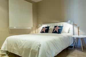 Apartament Turistics Cardona في كاردونا: غرفة نوم بسرير ابيض مع وسادتين