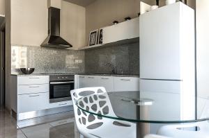 Apartament Turistics Cardona في كاردونا: مطبخ مع طاولة زجاجية واجهزة بيضاء