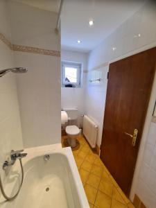 a bathroom with a bath tub and a toilet at B&B Hallstatt Lake - self check in in Obertraun