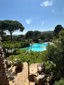 a view of a pool with chairs and a table at Hôtel Ambassador Palombaggia in Porto-Vecchio