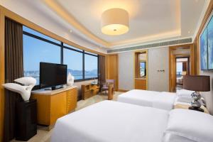 a hotel room with two beds and a flat screen tv at Four Points by Sheraton Hainan, Sanya in Sanya