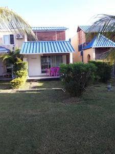 una casa con sedie rosa in un cortile di Aquamarine - Grand Baie - 3 chambres - Piscine a Grand Baie