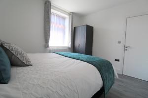 - une chambre avec un grand lit blanc et une fenêtre dans l'établissement F6 Hammonds Row, à Preston