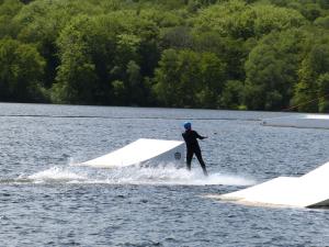 a man is water skiing on a lake at Domaine des Hameaux du Lac - BG in Saint-Pardoux