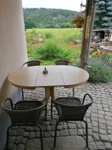 une table et deux chaises avec une table et un champ dans l'établissement Ferienwohnung Max, à Schirgiswalde