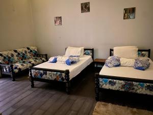 Zimmer mit 2 Betten, einem Stuhl und einem Sofa in der Unterkunft cairo central house in Kairo