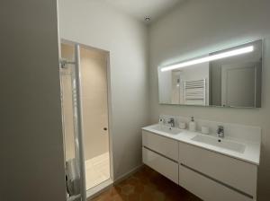 bagno bianco con lavandino e specchio di VENTOUX ad Apt