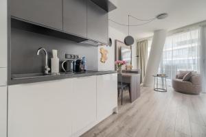 a kitchen with white cabinets and a table in a room at Your Holidays Waves B431 in Międzyzdroje