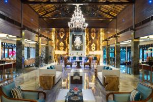 a lobby with a chandelier and a table and chairs at Sheraton Lampung Hotel in Bandar Lampung