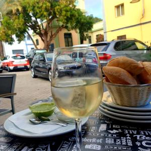 una copa de vino blanco sentada en una mesa con pan en San Andres Beach View Apartment en San Andrés