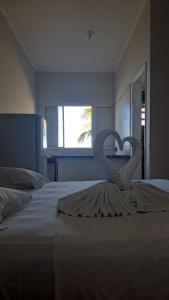 two swans are forming a heart on a bed at Hotel Pousada Miami in Itanhaém