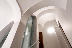 un pasillo con paredes blancas y techos abovedados en La casa di Oliva, en Macerata