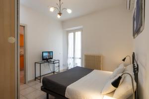 1 dormitorio con 1 cama y TV en La casa di Oliva, en Macerata