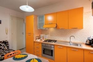 a kitchen with orange cabinets and a sink at La casa di Oliva in Macerata
