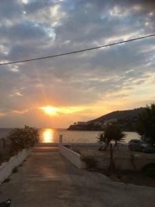 een zonsondergang boven een waterlichaam met een weg bij Siridaki Homes Leros in Agia Marina