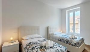1 dormitorio con 2 camas y ventana en Lecco delight - A perfect gateaway at Como lake en Lecco