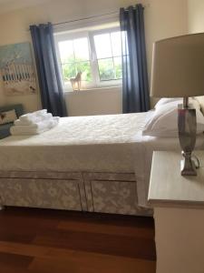 a bedroom with a large bed with a window at Camelias in Guimarães