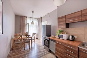 uma cozinha com armários de madeira e uma mesa com cadeiras em Retro Secret Apartment em Cracóvia