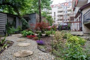 un jardín con rocas y flores en un patio en Retro Secret Apartment en Cracovia