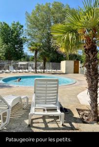 a pair of lawn chairs sitting next to a swimming pool at La Paillote de Claire in La Roque-dʼAnthéron