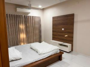 Habitación pequeña con cama y ventana en ASMA en Ahmedabad
