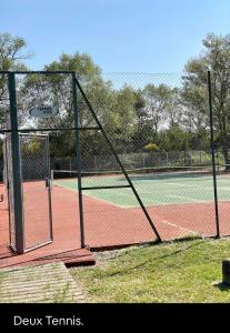 a tennis court with a net on a tennis court at La Paillote de Claire in La Roque-dʼAnthéron