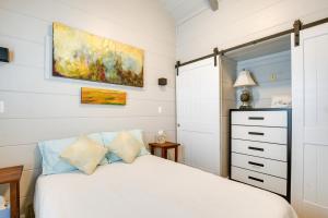 1 dormitorio con 1 cama y una pintura en la pared en Chic Flat Rock Tiny Home with Community Pool Access!, en Flat Rock