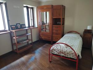 una camera con letto e cassettiera in legno di La Casa nel Borgo a Nocera Umbra