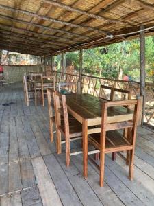 a wooden table and chairs on a patio at Soul Rebel Lodge & Backpackers in Nkhata Bay