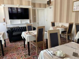 un ristorante con tavoli, sedie e un divano di The Sandrock a Clacton-on-Sea