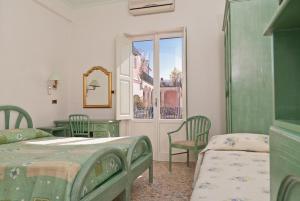 Hotel Del Postiglione tesisinde bir odada yatak veya yataklar